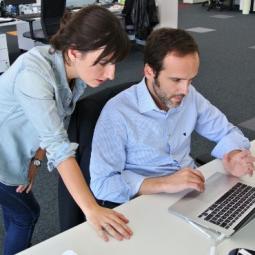 Two people looking at a desk top computer screen