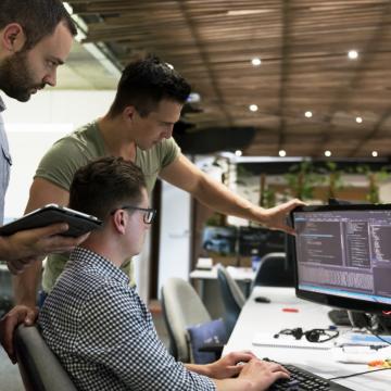 Trois jeunes qui regardent l'écran d'un ordinateur