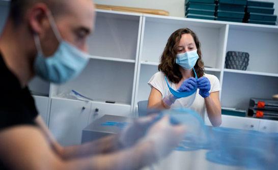 Professionals preparant material de protecció contra la covid