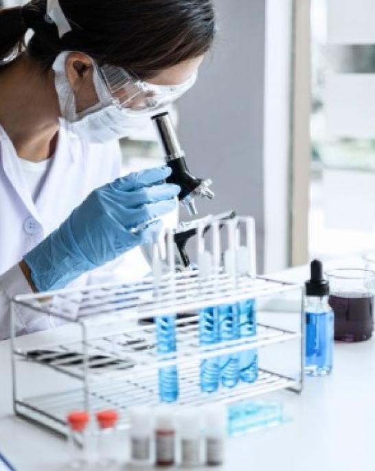 Researcher looking through a microscope